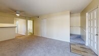 Located at 2690 Drew St in Clearwater, Florida, this two-story, two-bedroom, two-bathroom unit offers a functional and well-organized layout spread across two floors. The main level hosts the combined kitchen and living area, a dedicated kitchen, a hallway, and staircase access. The kitchen is equipped with white cabinetry, dark countertops, a stainless steel range, dishwasher, and refrigerator, complemented by light wood-style flooring and a window that brings in natural light. The living room features plush carpeting and a sliding glass door with vertical blinds that opens to an outdoor balcony, offering views of the surrounding area. The upper level contains both bedrooms, a hallway, a second staircase, and two full bathrooms. The spacious primary bedroom includes a closet and direct access to a private bathroom with wood-look tile flooring, a vanity, and a toilet. The second bedroom is comfortably sized and also features soft carpeting. Both bathrooms are finished with light, neutral tones and wood-look tile flooring. Throughout the unit, warm cream-colored walls, textured ceilings, and a mix of carpet and wood-style flooring create a cohesive, neutral aesthetic.