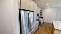 This contemporary apartment in Herndon, VA, offers 1190 square feet of thoughtfully designed living space. The layout comprises three bedrooms, including a primary bedroom of 140 square feet, and two well-appointed bathrooms. The heart of the home is an open-concept living area that seamlessly integrates the kitchen and living room, creating a spacious and inviting atmosphere.

The kitchen is a standout feature, boasting sleek, light-colored cabinetry, stainless steel appliances, and a stylish backsplash. A central island with a quartz countertop provides additional workspace and casual dining options. Pendant lighting adds a touch of modern elegance to the space.

Throughout the apartment, wood-look flooring lends warmth and durability. Large windows in the bedrooms and living areas flood the space with natural light, while offering views of the surrounding area. The bathrooms are designed with contemporary fixtures, including vanities with ample storage and modern lighting.

Storage is well-considered, with a walk-in closet featuring custom shelving and hanging space. The overall color palette is neutral, creating a bright and airy feel throughout. This single-floor apartment combines functionality with modern aesthetics, perfect for those seeking a stylish and comfortable urban living experience.