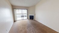 This single-floor residence offers a well-organized layout with a comfortable and functional design throughout. The living room serves as the heart of the space, featuring warm beige carpeting, a classic white-mantled fireplace, and a full-width sliding glass door that opens to a private balcony, allowing natural light to fill the room and providing views of the surrounding area. Soaring vaulted ceilings in the living and dining area add a sense of openness, while a textured ceiling treatment adds character throughout the home. The space transitions seamlessly from carpet to wood-look vinyl flooring as it flows into the kitchen and adjacent areas. The kitchen is efficiently designed with white cabinetry, granite-look countertops, a stainless steel sink, gas range, and dishwasher. A pass-through opening connects the kitchen to the living area, enhancing the open feel. The bedroom is carpeted and bathed in natural light through a generous window. The bathroom features a full-size tub and shower combo alongside a wide vanity with a speckled countertop, undermount sink, and a well-lit mirror. Overall, the space presents a clean, neutral palette well-suited for comfortable everyday living.