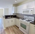 This 460 square foot apartment in Stamford, Connecticut, offers a compact yet well-designed living space. The single-floor layout maximizes functionality, featuring a modern kitchen, updated bathroom, and a spacious walk-in closet.

The kitchen is the heart of this home, boasting white cabinetry that extends to the ceiling, providing ample storage. Stainless steel appliances, including a gas range, refrigerator, and over-the-range microwave, offer convenience and style. Dark countertops contrast beautifully with the light cabinetry, while track lighting illuminates the workspace.

Adjacent to the kitchen, an open-concept living area benefits from natural light streaming through a large window. The bathroom features a single vanity with a modern light fixture, large mirror, and updated fixtures. A walk-in closet provides generous storage space with built-in shelving.

Throughout the apartment, light-toned wood-look flooring creates a sense of warmth and continuity. The neutral color palette and clean lines contribute to a contemporary aesthetic, making the space feel larger and brighter. This efficient apartment combines modern amenities with smart design, ideal for urban living.