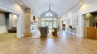 Located at 1 Maple Tree Lane in East Lyme, Connecticut, this single-floor community facility offers a thoughtfully designed and versatile environment across a generous footprint. The grand entrance lobby sets a refined tone with herringbone-patterned hardwood-style flooring, elegant column accents, vaulted ceilings, and a chandelier overhead. Vibrant artwork adorns the walls, while comfortable seating arrangements create a warm and inviting first impression, with natural light streaming through glass doors at the far end.

The facility includes a fully equipped kitchen featuring white shaker cabinetry with glass-front uppers, granite countertops, a stone tile backsplash, and stainless steel appliances. A dedicated coffee bar area with its own sink and dishwasher provides a convenient refreshment station. A well-organized package and mailroom offers shelving and storage for resident deliveries.

Private meeting rooms, finished in calming blue-gray tones with carpeted floors and natural window light, provide intimate spaces for small gatherings or discussions. A lively game room features a billiard table, foosball table, and a coffered ceiling with recessed lighting. A glass-enclosed fitness center near the main entrance is equipped with cardio and strength training machines, completing this comprehensive and community-focused space.
