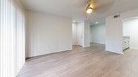 Located at 2550 Stag Run Blvd in Clearwater, Florida, this single-floor unit offers a clean, modern aesthetic throughout. Light wood-style flooring runs consistently across all living areas, bedrooms, and the bathroom, creating a cohesive and airy feel. White walls and textured ceilings complement the neutral palette, while ceiling fans with integrated lighting are present in the main living spaces.

The living area is generously proportioned, featuring a sliding glass door dressed with vertical blinds that opens to an outdoor view, allowing abundant natural light to fill the room. An additional open living or dining area connects seamlessly, enhancing the sense of flow and space.

The galley-style kitchen is efficiently designed with dual countertop runs, white cabinetry with modern hardware, stone-look countertops, and stainless steel appliances including a refrigerator, dishwasher, and range.

The bedrooms are well-sized and bright, each equipped with windows fitted with blinds offering outdoor views and closets with louvered doors. The bathroom features a white vanity with a stone-look countertop, a large mirror, and a full tub-shower combination with white tile surround. The overall layout, as seen in the dollhouse view, is practical and well-organized, making excellent use of the available footprint.