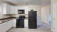 Located at 3602 Wilmington Ave in Hopewell, Virginia, this single-floor home offers a well-organized layout with a clean, neutral aesthetic throughout. The kitchen is a functional highlight, featuring white cabinetry with crown molding detail, dark granite-style countertops, a double stainless steel sink, and black appliances including a range, built-in microwave, and dishwasher. A pendant light above the sink and a window overlooking the outdoors add brightness and character to the space. Light wood-style flooring runs through the kitchen and common areas, providing a cohesive flow.

The bedrooms are carpeted and finished with neutral walls and white trim, each offering a comfortable, versatile space. Several bedrooms include sliding double-door closets, and windows allow natural light to filter in. One larger bedroom features a ceiling fan, adding to its comfort.

The home includes two bathrooms, both showcasing dual-sink vanities with white cabinetry and white countertops, brushed nickel fixtures, and large mirrors with Hollywood-style lighting. One bathroom includes a window and a tub with a decorative shower curtain, while the other offers a clean, minimalist design. The overall ambiance of the home is bright, tidy, and move-in ready.