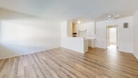 Located at 19962 Roscoe Blvd in the Winnetka neighborhood of Los Angeles, this apartment offers a clean, functional layout across a single floor. The open living area is bright and airy, featuring warm wood-style laminate flooring and crisp white walls that create a light, neutral atmosphere. A textured ceiling adds subtle character throughout the common spaces. Natural light filters in through a large front-facing window, which also houses a wall-mounted air conditioning unit for year-round comfort.

The kitchen is positioned at the heart of the unit, separated from the living room by a half-wall peninsula that provides both counter space and visual separation. White cabinetry and a built-in four-burner gas cooktop with an overhead range hood complete the kitchen's functional design.

The bedroom is a quiet, well-proportioned retreat, also finished with wood-style flooring. A built-in closet with a sliding door and open shelving provides ample storage. The room connects directly to the rest of the unit through a clean, simple doorway.

The bathroom is finished in an all-white palette with wood-style flooring that ties in with the rest of the unit. It includes a combination tub and shower with a window above for ventilation and natural light, a toilet, and a vanity with white cabinetry and countertop. A wall vent and gold-toned door hardware add subtle classic touches to the space.