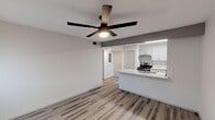 Located at 1350 E Northern Ave in Phoenix, AZ, this single-floor unit offers a clean, modern aesthetic with thoughtfully updated finishes throughout. The open-concept living and kitchen area is anchored by durable wood-look plank flooring and a sleek ceiling fan with integrated lighting, creating a bright and comfortable environment. Large windows allow natural light to fill the living space, enhancing its airy, welcoming atmosphere.

The kitchen is a standout feature, designed with functionality and style in mind. It includes an expansive granite-topped island with a double stainless steel sink, providing ample workspace and a natural gathering point. Gray shaker-style cabinetry lines both sides of the kitchen corridor, complemented by stainless steel appliances including a gas range and a full-size refrigerator. Recessed and flush-mount overhead lighting ensures excellent task illumination throughout.

A spacious bedroom features the same wood-look flooring, a ceiling fan, and a well-sized window with blinds for light control and privacy. The bathroom maintains the same contemporary palette, showcasing gray cabinetry with a granite vanity top, a single undermount sink, and wood-look flooring that ties the space together cohesively. A double-door closet provides convenient storage. The overall design emphasizes a neutral, modern tone ideal for a variety of living arrangements.