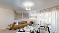 Located in Wellington, FL, this well-appointed 2-bedroom, 2-bathroom single-floor residence offers a thoughtfully designed open layout with a warm, neutral palette throughout. Light wood-style flooring flows seamlessly across the main living areas, creating a cohesive and airy ambiance. The living room is a welcoming focal point, featuring a textured ceiling, a stylish flush-mount light fixture, and a large window dressed with sheer curtains that invite abundant natural light. The kitchen is bright and functional, outfitted with white shaker cabinetry, light quartz countertops, stainless steel appliances, and a skylight-style ceiling detail that further enhances the sense of openness. Adjacent to the kitchen, the dining area accommodates a full-sized table beneath a modern track light fixture. A well-lit hallway connects the main living spaces to the bedrooms, with the primary bedroom offering a ceiling fan, generous closet space, and a private en-suite bathroom. Both bathrooms are finished with white vanities, light quartz surfaces, and large mirrors with modern fixtures. A utility room and an attached garage round out the practical features of this residence, making it a complete and comfortable home.