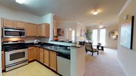 Located at 223 Indiana Ave in Lubbock, TX, this single-floor residence offers a thoughtfully designed open-concept layout that seamlessly connects the kitchen and living areas. The kitchen is well-equipped with warm honey-toned cabinetry, dark granite countertops, stainless steel appliances including a smooth-top range, built-in microwave, and dishwasher, along with a double-basin sink and light hardwood-style flooring. A breakfast bar peninsula provides a natural transition into the open living space, which features plush carpeting, crown molding, a ceiling fan, and French doors that invite abundant natural light and outdoor access. The living room offers a welcoming atmosphere with generous wall space suited for artwork displays. The bedroom is carpeted and bright, benefiting from large windows dressed with elegant sheer curtains and blinds, crown molding, and a ceiling fan. The bathrooms are finished with rich wood cabinetry, dark granite countertops, hardwood-style flooring, and tub-shower combinations. A dedicated in-unit laundry room with side-by-side washer and dryer hookups and storage shelving adds everyday convenience. Throughout, the residence maintains a cohesive, comfortable aesthetic with consistent finishes.