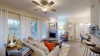 Located at 2116 Marsh Ln in Carrollton, Texas, this single-story residence offers a well-designed layout with a cohesive blend of comfort and modern finishes throughout. The living room serves as the heart of the home, featuring a corner fireplace, crown molding, a ceiling fan, and wood-style flooring. Natural light fills the space through large windows dressed with grommet-panel curtains, while a sliding glass door provides direct access to the outdoors. The dining area is defined by elegant crown molding and a pendant light fixture overhead, creating an inviting setting for meals. The kitchen is equipped with granite countertops, dark wood cabinetry, a white subway tile backsplash, and black appliances including a range and over-the-range microwave. The bedroom offers plush carpeting, a ceiling fan, a large window with natural light, and ample storage. The bathroom features a dark wood vanity with granite countertops, a large mirror, and a shower-tub combination. A dedicated laundry area with overhead cabinetry and wood-style flooring adds everyday convenience. A hallway with vaulted ceiling details connects the main living spaces to the bedroom, completing this thoughtfully designed single-floor home.