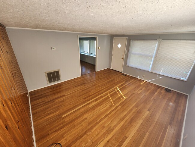 View from back left of living room to front door and kitchen. - 1104 Spring St