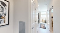 Located at 3811 Commerce Way in Sacramento, CA, this thoughtfully designed one-bedroom, one-bathroom unit maximizes its compact footprint with a smart, open-concept layout. The combined kitchen and living area serves as the heart of the home, bathed in natural light from a large picture window that frames views of the surrounding neighborhood. Soaring ceilings and a ceiling fan enhance the sense of openness in the living space, which features light wood-tone flooring throughout.

The kitchen is outfitted with contemporary two-tone cabinetry — pairing light upper cabinets with wood-grain lower units — complemented by a white tile backsplash, quartz countertops, and a full suite of stainless steel appliances including a range, dishwasher, microwave, and refrigerator. Open shelving adds both storage and visual interest.

The bedroom offers a cozy retreat with a wall-mounted TV, a ceiling fan, and a clerestory window that brings in additional natural light. A dedicated walk-in closet provides ample storage with wire shelving and hanging rods. The full bathroom features wood-look flooring, a tub/shower combination, and clean, neutral finishes throughout. This unit delivers a modern, functional living experience in a well-appointed Sacramento location.