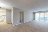 Located at 14000 Castle Blvd in Silver Spring, Maryland, this one-bedroom, one-bathroom unit offers a well-organized single-floor layout designed for comfortable everyday living. The combined kitchen and living area forms the heart of the home, with the kitchen featuring white cabinetry, granite-style countertops, a gas range, and tile flooring that provides a clean, functional workspace. The living area flows naturally from the kitchen and is carpeted throughout, creating a warm and cohesive feel. A large sliding glass door floods the living room with natural light and opens to a private balcony with outdoor views, enhancing the sense of openness in the space. A hallway connects the main living area to the bedroom and bathroom, providing a clear and efficient layout. The generously sized bedroom is carpeted and features a wide louvered double closet offering abundant storage. A second closet is also visible near the main living area, adding further storage convenience. The bathroom includes a full tub-shower combination with clean white tile surround. Neutral tones, textured ceilings, and consistent carpeting throughout the living and sleeping areas contribute to a cohesive and move-in-ready aesthetic throughout this well-appointed Silver Spring residence.