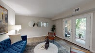 Located in Atlanta's desirable Druid Hills neighborhood, this well-appointed two-bedroom, two-bathroom residence offers a thoughtfully designed single-level floor plan. The open-concept living and dining area is anchored by wood-style flooring, neutral walls, and abundant natural light streaming through French doors that lead to a private balcony overlooking lush greenery — an inviting extension of the living space. The living room provides generous room for entertaining, while the adjacent dining area is defined by a pendant light fixture and easy flow into the kitchen. The kitchen features white shaker cabinetry, dark countertops, a subway tile backsplash, stainless steel appliances including a gas range and refrigerator, and a skylight that brightens the space throughout the day. Both bedrooms are carpeted for comfort, each equipped with a ceiling fan and ample closet space. The primary bedroom includes a walk-in closet and room for large furniture. The second bedroom offers similar comfort and natural light. Two full bathrooms serve the residence, one featuring a tub-shower combination with white cabinetry and dark countertops, maintaining the cohesive design aesthetic found throughout this well-balanced Atlanta home.