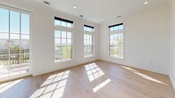 Located on Pesserelle Court in the heart of Charleston, SC, this thoughtfully designed three-story home offers 2 bedrooms and 3 full bathrooms across a well-appointed layout. The ground floor features an attached garage and utility spaces, providing convenient storage and functionality. The main living level showcases a stunning open-concept kitchen and dining area, where light gray shaker cabinetry with gold hardware meets a dramatic marble-look backsplash and quartz countertops. A bold navy blue island anchors the space, illuminated by a trio of glass-and-brass pendant lights, while a professional-grade stainless range and undermount sink complete the chef-inspired kitchen. Light hardwood flooring flows throughout the main and upper levels, enhancing the home's bright, airy ambiance. The living room adds comfortable gathering space, complemented by recessed lighting throughout. Upstairs, the bedrooms are generously proportioned, with large multi-pane windows framing beautiful outdoor views, including glimpses of the water, and flooding rooms with abundant natural light. The primary bedroom offers its own closet, while the bathrooms feature refined finishes including tile flooring, shaker-style vanities, and polished chrome fixtures. A herringbone-patterned floor detail and dedicated laundry room add further distinction to this polished Charleston home.