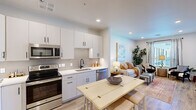 Located at 9449 North 90th Street in Scottsdale, Arizona, this single-floor, one-bedroom, one-bathroom residence offers a thoughtfully designed open-concept layout. The kitchen is a standout feature, showcasing white shaker-style cabinetry with matte black hardware, quartz countertops, a textured tile backsplash, and a full suite of stainless steel appliances including a French door refrigerator, electric range, microwave, and dishwasher. A dining table sits adjacent to the kitchen, creating a seamless flow into the living area. The living room is bright and welcoming, with recessed lighting, large windows with natural light, and direct access to an exterior door. Light wood-tone flooring runs throughout the unit, adding warmth and continuity. The bedroom comfortably accommodates a full-sized bed, features a ceiling fan, a window with exterior views, and double closet doors offering generous storage. The bathroom is finished with a marble-style walk-in shower, a single vanity with white cabinetry, and wood-look flooring. Clean lines and a neutral palette give this Scottsdale residence a modern, move-in-ready appeal.