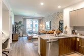 Located at 1200 Rickabaugh Way in Santa Clara, CA, this thoughtfully designed one-bedroom, one-bathroom residence offers a cohesive open-concept layout that maximizes every square foot. Light wood-style flooring runs throughout, lending warmth and continuity across all rooms.

The kitchen is a standout feature, equipped with stainless steel appliances including a gas range, microwave, and full-size refrigerator. Sleek two-tone cabinetry in warm wood and matte gray pairs with quartz countertops and a peninsula with bar seating — ideal for casual dining and entertaining. The kitchen opens directly into the living room, which is anchored by a striking abstract-patterned accent wall and large windows that invite natural light and outdoor views.

The bedroom is a comfortable retreat, highlighted by a textured accent wall, natural light from a well-positioned window, and direct access to a generously sized walk-in closet outfitted with a full adjustable shelving and hanging system. The hallway connecting the rooms is clean and functional, providing a smooth flow throughout the home.

Recessed lighting throughout, a built-in desk nook, and a well-organized bathroom round out this efficient yet stylish residence in the heart of Silicon Valley.