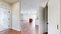 This 2-bedroom, 2-bathroom residence offers a practical and modern single-floor layout designed for comfortable everyday living. The open-concept kitchen and living area serves as the heart of the home, featuring warm wood-look flooring that extends throughout the main living spaces. The kitchen is well-equipped with white shaker cabinetry, quartz countertops, a subway tile backsplash, stainless steel appliances including a gas range and French door refrigerator, a double-basin sink with a brushed nickel faucet, and a central island with pendant lighting overhead. A sliding glass door connects the kitchen to an outdoor area, allowing natural light to fill the space. The living room is open and airy, with recessed lighting and a clean, neutral palette throughout. Both bedrooms are generously sized, featuring plush carpeting, large windows with blinds for natural light and privacy, and easy access to a dedicated closet. The two bathrooms are finished with white vanity cabinetry, quartz countertops, undermount sinks, brushed nickel fixtures, large framed mirrors, and wood-look flooring, presenting a clean and contemporary aesthetic. Overall, the residence presents a cohesive, move-in-ready interior with modern finishes and a functional, well-organized floor plan.
