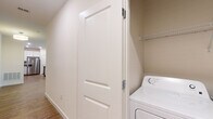 This single-floor residence offers a thoughtfully designed layout that balances functionality and modern style throughout. The open living area serves as the heart of the home, featuring warm hardwood-style flooring, a ceiling fan with light fixture, and generous windows fitted with blinds that invite ample natural light while maintaining privacy. A secondary door provides convenient exterior access directly from the living space.

The kitchen is equipped with stainless steel appliances — including a refrigerator with ice and water dispenser, electric range, and over-the-range microwave — complemented by crisp white shaker-style cabinetry, granite countertops, and matching hardwood-style flooring that ties seamlessly into the living area.

Bedrooms are finished with plush carpeting and feature large windows that bring in natural light and outdoor views, creating a calm and restful atmosphere. The bathroom is finished with consistent granite countertops, a white shaker vanity, a tiled tub-and-shower combination, and hardwood-style flooring — offering a clean, cohesive aesthetic.

An in-unit laundry area with a washer and overhead storage shelving adds practical convenience. Throughout the residence, neutral tones, white trim, and panel-style interior doors contribute to a clean, contemporary feel.
