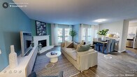 Located in the established Stonehenge neighborhood of Raleigh, NC, this single-floor residence offers a thoughtfully designed layout with a warm, livable aesthetic throughout. The kitchen stands out with crisp white cabinetry, stone-look countertops, stainless steel appliances including a dishwasher and refrigerator, and a stainless undermount sink positioned beneath a sun-filled window. Wood-look flooring runs through the kitchen, which also benefits from an adjacent door providing direct outdoor access and abundant natural light. A pantry closet adds practical storage to the space.

The bedrooms are carpeted and generously sized, each featuring large windows with outdoor views that fill the rooms with natural light. One bedroom showcases a calming teal accent wall and dual windows, while another offers neutral tones with a ceiling fan fixture and soft, layered lighting. Both spaces provide a comfortable and versatile feel.

The bathroom features classic white subway tile surrounding a full soaking tub and shower combination, complemented by a patterned shower curtain, wood-look flooring, and a marble-style countertop vanity. The 3D floor plan reveals an open, connected living and dining area that anchors the home's interior, creating a cohesive flow between all rooms.