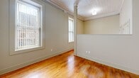 Located at 1601 Main St in the heart of Columbia, SC, this single-floor unit offers an efficiently designed layout that makes excellent use of its intimate footprint. The main living area immediately impresses with rich, warm hardwood flooring that extends throughout, complemented by neutral, earthy wall tones and classic crown molding. Multiple windows allow natural light to pour in, creating a bright and welcoming ambiance. A decorative textured ceiling adds a touch of historic character, while structural columns subtly define the open layout.

The kitchen is thoughtfully equipped with stainless steel appliances, including a full-size refrigerator and electric range, granite-style countertops, a stainless double sink, and ample upper cabinetry in a contemporary gray finish — offering both style and practicality in a compact space. Hardwood flooring continues seamlessly into the kitchen, maintaining a cohesive aesthetic throughout.

The bathroom features clean, neutral finishes with light gray tile flooring, crisp white fixtures, and generous baseboard trim, keeping the space simple and functional. Throughout the unit, consistent warm beige tones, detailed millwork, and quality finishes reflect a careful blend of classic architectural character and modern updates, making this an ideal space in a prime downtown Columbia location.