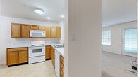 Located at 8555 Alexandra Dr in North Royalton, Ohio, this single-floor, one-bedroom, one-bathroom residence offers a practical and well-organized layout. The kitchen is equipped with warm honey-toned wood cabinetry, a double sink, white appliances including an electric range, microwave, dishwasher, and refrigerator, and is finished with light tile flooring. Recessed lighting and a flush ceiling fixture provide ample illumination throughout the kitchen area. Adjacent to the kitchen is a dedicated dining space with light tile flooring and an elegant chandelier overhead, adding a classic touch to the room. A carpeted hallway connects the main living areas, featuring panel-style doors and a generous closet for storage. The bedroom is a comfortable size, with plush carpeting, a window dressed with blinds that allows natural light, and access to a closet. The bathroom is thoughtfully designed with accessibility in mind, featuring stainless steel grab bars, tile flooring, and a glass-enclosed shower. Throughout the unit, neutral white and cream tones on the walls create a clean, bright atmosphere that is easy to personalize. The overall layout is efficient and cohesive, making this residence a practical option in the North Royalton community.