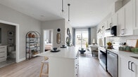 Located at 162 McCarthy Road West in Stratford, Ontario, this thoughtfully designed one-bedroom, one-bathroom unit offers a modern and efficient layout across a single floor. The open-concept kitchen and living area serves as the heart of the home, featuring crisp white shaker cabinetry with matte black hardware, quartz countertops, stainless steel appliances, and a central island with bar seating — all illuminated by globe pendant lights. Light-toned hardwood-style flooring runs throughout, enhancing the bright and airy atmosphere. The living room is anchored by a large sliding glass door that invites natural light and connects the interior to the outdoors. The bedroom is a calm, well-proportioned retreat with a window offering natural light and ample space for a full furniture arrangement. A dedicated office provides a quiet nook with floating shelves, ideal for remote work or study. The bathroom is finished with dark marble-effect tile on the floors and tub surround, contrasted by a clean white vanity with black hardware, creating a bold yet refined aesthetic. Every room reflects a cohesive contemporary design sensibility, making this unit a polished and functional living space in the heart of Stratford.