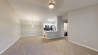 Located at 4319 Preston Pointe Way in Cumming, Georgia, this single-floor home offers a thoughtfully designed open-concept layout with a warm, neutral color palette throughout. The living area features plush carpeting, vaulted ceilings, and decorative columns that define the space while maintaining an open, airy feel. A ceiling fan with lighting adds both function and comfort.

The kitchen is a standout feature, equipped with stainless steel appliances including a refrigerator, range, microwave, and dishwasher. White cabinetry, a grey subway tile backsplash, and a peninsula with a breakfast bar create a clean, modern aesthetic. Wood-look flooring grounds the kitchen and flows into the adjacent dining area, which is accented by a pendant light fixture.

The bedrooms are generously sized with soft carpeting, ceiling fans, and ample natural light from windows fitted with blinds. Several bedrooms offer walk-in closet access and connect to well-appointed bathrooms. The bathrooms feature white vanities with undermount sinks, wood-look tile flooring, soaking tubs, and tiled shower surrounds, providing a clean and contemporary finish.

A laundry area is conveniently accessible from one of the bedrooms, adding practical functionality to this well-organized home.