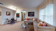 This single-floor residence in Grove City, Ohio offers a comfortable and functional layout designed for everyday living. The open living room is carpeted and bathed in natural light from multiple windows with blinds, and flows seamlessly into a dedicated dining area. The kitchen is well-appointed with warm oak cabinetry extending to the ceiling, light countertops, a double stainless steel sink, a dishwasher, stainless steel refrigerator, and a range. A peninsula with seating for two adds a convenient casual dining option. The primary bedroom features plush carpeting, a bold accent wall, and ample space, with direct access to an en-suite bathroom equipped with a walk-in shower. The second bedroom is bright and serene, with large windows framed by elegant drapes. A second full bathroom includes a tub-shower combination with wood-look flooring. Throughout the residence, textured ceilings, neutral wall tones, and wood-trim details contribute to a warm and inviting ambiance. The entryway offers a welcoming introduction to the home with framed wall art and a console table. This well-maintained single-floor home provides a practical and comfortable living environment in a residential Grove City community.