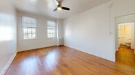 Located at 2505 W 6th St in Los Angeles, CA, this efficient one-bedroom, one-bathroom unit offers a well-designed layout across a single floor. The spacious primary bedroom features warm hardwood flooring, crisp white walls, multiple windows that invite abundant natural light, a ceiling fan with light fixture, and a classic cast-iron radiator — combining comfort with classic character. Closet space is notably generous for a unit of this size, with five closets distributed throughout, providing exceptional storage solutions. The combined dining room and kitchen area is a standout, showcasing white cabinetry with gold hardware, dark granite countertops, a decorative patterned tile backsplash, and a full suite of stainless steel appliances including a gas range, over-the-range microwave, and a large French door refrigerator. Natural light filters in through a window above the sink, brightening the space. The bathroom is clean and functional, featuring large-format tile flooring in a warm gray tone, white subway-tiled walls, a full soaking tub with shower, and a pedestal sink. Two hallways connect the rooms seamlessly, contributing to a practical and cohesive flow throughout the unit.