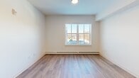 Located at 110 Bristol Ferry Rd in Portsmouth, Rhode Island, this one-bedroom, one-bathroom unit offers a thoughtfully designed single-floor layout with modern finishes throughout. The open-concept living and kitchen area is anchored by warm-toned hardwood-style flooring and recessed lighting, creating a bright and welcoming atmosphere. Large windows allow generous natural light to fill the space while providing views of the surrounding area.

The kitchen is well-appointed with rich dark-espresso cabinetry, light countertops, and a full suite of stainless steel appliances, including a gas range, dishwasher, and refrigerator. Ample cabinet storage and an under-mount sink complete the functional layout.

The spacious bedroom features a large window with natural light, baseboard heating, and easy access to multiple closets, including generous storage options throughout the hallway. The bathroom is designed with accessibility in mind, featuring ADA-compliant grab bars, a floating dark-wood vanity with a white countertop, tile flooring, and a clean, minimalist aesthetic.

The unit includes three closets, providing exceptional storage for its size. With a contemporary, neutral color palette of crisp white walls and light flooring, this Portsmouth residence offers a clean, move-in-ready living environment.