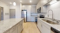 Located at 528 Summit Way in Mount Juliet, Tennessee, this single-story unit offers a thoughtfully designed layout with contemporary finishes throughout. The kitchen serves as a central highlight, featuring gray shaker-style cabinetry, granite countertops, a tile backsplash, stainless steel appliances including a refrigerator, range, and microwave, and pendant lighting above a peninsula that provides additional prep and seating space. Light wood-style flooring runs through the kitchen and main living areas, contributing to a clean, modern aesthetic.

The living area is generously sized, with a ceiling fan and a glass door leading to a private balcony, allowing natural light to fill the space. Multiple bedrooms are finished with plush carpet, ceiling fans, and windows that bring in outdoor views. One bedroom includes access to a walk-in closet with wire shelving, offering practical storage. The bathroom is well-appointed with gray cabinetry, granite countertops, a large framed mirror, and wood-look tile flooring. Additional rooms with hard-surface flooring provide flexible space for various uses. Overall, the unit presents a clean, move-in-ready environment with consistent modern detailing.