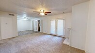 Located in Lubbock, TX, this single-story, 5-bedroom, 3-bathroom home offers a practical and well-organized layout designed to accommodate multiple occupants comfortably. The living room serves as the heart of the home, featuring a classic brick fireplace, soft carpeted floors, a textured ceiling, a ceiling fan with light fixture, and sliding glass doors fitted with blinds that allow natural light to filter in. The bedrooms are carpeted and include ceiling fans, with select rooms featuring closets and windows with blinds. The generously sized primary bedroom provides ample space for furnishings. The three bathrooms are clean and functional, each equipped with a tub-shower combination. The primary bath features a wide vanity with white cabinetry, a built-in mirror with overhead lighting, and wood-look flooring. The kitchen includes warm wood-toned cabinetry and connects seamlessly to the main living areas. A carpeted hallway with a built-in closet links the bedrooms, enhancing privacy and flow. The laundry area includes washer and dryer hookups behind vertical blinds. Throughout the home, a consistent neutral color palette and textured walls create a clean, understated aesthetic.