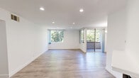 Located in Los Angeles, CA, this 2-bedroom, 1-bathroom unit offers a well-organized single-floor layout designed for comfortable everyday living. The open living room serves as the heart of the home, featuring light wood-style flooring, recessed lighting, and a classic fireplace with a white mantle — an inviting focal point for the space. A wet bar area adds a convenient touch near the entrance.

The galley kitchen is thoughtfully appointed with dark espresso cabinetry, granite-look countertops, a double sink, and white appliances including a refrigerator, range, and over-the-range microwave. Recessed lighting illuminates the kitchen throughout.

The spacious primary bedroom includes mirrored sliding closet doors that enhance the sense of space, soft carpet flooring, and direct access to the bathroom, which features a granite vanity, a combined tub and shower, and clean white finishes. The second bedroom offers light wood flooring, a large window with garden views, and recessed lighting.

A private balcony provides a tranquil outdoor retreat surrounded by mature, lush greenery under the Southern California sun. Both bedrooms receive ample natural light through windows framing verdant tree canopy views, giving the unit a serene, nature-connected feel throughout.