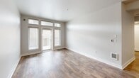 Located at 1705 Dock St in Tacoma's vibrant waterfront district, this 2-bedroom, 2-bathroom unit offers a well-designed single-floor layout. The open-concept living, dining, and kitchen area forms the heart of the home, anchored by warm wood-style flooring that flows throughout the main spaces. The kitchen is equipped with stainless steel appliances — including a refrigerator, range, microwave, and dishwasher — complemented by warm wood cabinetry, dark countertops, a peninsula with a double sink, and a tile backsplash. A pantry provides additional storage convenience. The spacious living area is bright and open, leading to a private balcony that overlooks the surrounding urban streetscape and nearby landmarks. Both bedrooms feature plush carpet flooring and large windows fitted with blinds, allowing for ample natural light. The primary bedroom includes generous closet space. Each bathroom is finished with wood-toned vanity cabinetry, a large mirror, and wood-style tile flooring. Additional hallway closets offer practical storage throughout. With four closets in total, the layout is designed with organization in mind, making this a functional and comfortable urban residence.