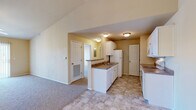 Located at 2015 W University St in Springfield, MO, this one-bedroom, one-bathroom unit offers a well-organized, single-floor layout designed for comfortable everyday living. The open-concept living area is carpeted and filled with natural light from a sliding glass door that leads to an outdoor patio, complemented by a ceiling fan overhead. The kitchen is designed in a galley style, featuring white cabinetry, dark laminate countertops, a double-basin sink, and white appliances including a refrigerator, electric range, and over-the-range microwave. A peninsula counter connects the kitchen to the living space, creating a functional flow between the two areas. The spacious bedroom includes a tray ceiling with a ceiling fan, a large window for natural light, and a sliding mirrored closet door providing ample storage. An additional closet and a dedicated laundry area with hookups add practical convenience. The bathroom is cleanly appointed with a single-sink vanity, tiled flooring, and a full tub-shower combination. Throughout the unit, neutral tones and consistent finishes create a cohesive and move-in-ready living environment.