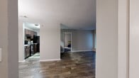 Located at 100 Ashley Creek Circle in Stone Mountain, GA, this single-floor, 2-bedroom, 2-bathroom home offers a practical and comfortable layout with a variety of functional spaces. Wood-look plank flooring flows throughout the main living areas, creating a cohesive and easy-to-maintain aesthetic. The living room serves as a central gathering space anchored by a classic brick fireplace with a white mantel and a sliding glass door that brings in natural light. Adjacent to the living room, the dining area features a pendant light fixture and a tall, narrow window, with direct sightlines into the kitchen. The galley-style kitchen is outfitted with dark espresso cabinetry, a mosaic tile backsplash, light stone countertops, and black appliances. A dedicated laundry room with wire shelving and washer/dryer hookups adds everyday convenience. Both bedrooms are carpeted and receive natural light through large windows with views of surrounding greenery. The generously sized primary bedroom includes two closets. Two full bathrooms, each with a tub-shower combination and wood-look flooring, complete the layout. Two closets provide additional storage throughout the home.