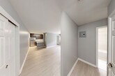 Located at 211 Hawthorne Ave in Central Islip, NY, this 2-bedroom, 1-bathroom unit offers a thoughtfully updated interior with a clean, modern aesthetic throughout. Light-toned hardwood flooring flows seamlessly across the open living and dining area, lending a bright and cohesive feel to the space. The kitchen is well-appointed with dark cabinetry, a marble-style tile backsplash, stainless steel refrigerator, gas range, dishwasher, and a peninsula counter that provides additional prep space and casual seating. The primary bedroom is generously proportioned, featuring a window that brings in natural light, a wall-mounted AC unit, and baseboard heating. The second bedroom is comfortably sized with its own window and baseboard heating. The full bathroom has been tastefully renovated with large-format neutral tile, a white vanity, and a full soaking tub with shower. Four closets throughout the unit offer ample storage. A private balcony off the unit overlooks a tree-lined parking area, providing a quiet outdoor retreat. The building exterior features classic brick construction, and the surrounding greenery adds a serene backdrop to this well-maintained Central Islip residence.