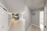 Located at 211 Hawthorne Ave in Central Islip, NY, this 2-bedroom, 1-bathroom unit offers a thoughtfully updated interior with a clean, modern aesthetic throughout. Light-toned hardwood flooring flows seamlessly across the open living and dining area, lending a bright and cohesive feel to the space. The kitchen is well-appointed with dark cabinetry, a marble-style tile backsplash, stainless steel refrigerator, gas range, dishwasher, and a peninsula counter that provides additional prep space and casual seating. The primary bedroom is generously proportioned, featuring a window that brings in natural light, a wall-mounted AC unit, and baseboard heating. The second bedroom is comfortably sized with its own window and baseboard heating. The full bathroom has been tastefully renovated with large-format neutral tile, a white vanity, and a full soaking tub with shower. Four closets throughout the unit offer ample storage. A private balcony off the unit overlooks a tree-lined parking area, providing a quiet outdoor retreat. The building exterior features classic brick construction, and the surrounding greenery adds a serene backdrop to this well-maintained Central Islip residence.