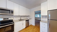 Located at 38 Convay Cres in Brockville, Ontario, this single-floor unit offers three bedrooms and one bathroom within a efficiently designed layout. Warm hardwood-style flooring runs throughout the entire unit, lending a cohesive and inviting feel to every room.

The kitchen is a standout feature, outfitted with crisp white shaker-style cabinetry extending to the ceiling for ample storage, grey quartz-style countertops, a subway tile backsplash, and a full suite of stainless steel appliances including a range, over-the-range microwave, and dishwasher. A pass-through opening connects the kitchen to the adjacent living area, enhancing the sense of openness.

The spacious primary bedroom benefits from a wide sliding window framing views of mature trees, while the two additional bedrooms are well-proportioned with their own windows overlooking the surrounding neighbourhood. Each room is equipped with baseboard heating for year-round comfort.

The bathroom is finished in a clean, all-white palette featuring subway tile surround, a combined tub and shower, a single vanity, and a frosted privacy window. Throughout the unit, neutral white walls and consistent flooring create a bright, move-in-ready environment.