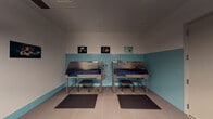 Located at 899 Congress St in Boston, MA, this purpose-built dog wash facility is designed to provide a clean, functional, and welcoming environment for pet grooming. The space is unified by a distinctive aqua-blue subway tile wainscoting that runs along the lower half of all walls, paired with smooth light gray upper walls and large-format tile flooring, creating a hygienic and visually cohesive aesthetic throughout.

The primary washing area features multiple stainless steel bathing stations equipped with blue non-slip mats, handheld spray hoses, and mounted shelving for grooming products. Each station includes a step stool for easy pet access, and anti-fatigue rubber mats on the floor provide comfort for groomers during extended use. A dedicated grooming area houses a height-adjustable grooming table with an integrated restraint arm, illuminated by overhead pendant lighting.

Throughout the space, framed photographs of dogs underwater add a playful, pet-centric character to the walls. A bench and wall hooks near the entry door offer convenient storage for personal belongings. The facility also includes open wall space that allows for flexible arrangement of additional equipment. The overall design prioritizes ease of cleaning, safety, and functionality, making it a well-equipped professional environment for dog bathing and grooming services.