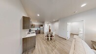 Located at 400 N Terrace Blvd in Angola, Indiana, this single-floor unit offers a well-organized layout that efficiently utilizes its available space. Light-toned luxury vinyl plank flooring runs throughout, contributing to a clean, cohesive aesthetic across all rooms.

The kitchen is a functional highlight, featuring warm medium-toned wood cabinetry with ample upper and lower storage, white countertops, and a full suite of stainless steel appliances including a refrigerator, electric range, and over-the-range microwave. The kitchen opens directly to a dining area, accommodating a round table and chairs, making it ideal for everyday use.

Adjacent to the dining space, the living room provides a comfortable retreat with recessed lighting, a wall-mounted television, and a window that admits natural light. The bedroom is bright and quietly understated, with a window overlooking the exterior, recessed lighting, and sufficient space for standard furnishings including a dresser and bed. A private bathroom is accessible directly from the bedroom corridor. A short hallway connects the private sleeping quarters to the shared living areas, maintaining a clear and logical flow throughout the unit. The overall ambiance is modern, neutral, and move-in ready.