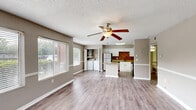 Located at 401 W Seminole Blvd in Sanford, FL, this well-appointed 2-bedroom, 1-bathroom residence offers a practical and comfortable single-floor layout. The open-concept living area features light wood-style flooring, a ceiling fan, and multiple windows fitted with blinds that allow abundant natural light to fill the space. Neutral taupe walls and a textured ceiling create a warm, cohesive aesthetic throughout.

The kitchen is a standout feature, equipped with white cabinetry, granite countertops, a decorative tile backsplash, stainless steel appliances — including a refrigerator, range, microwave, and dishwasher — and a center island ideal for meal prep or casual dining. An in-unit washer is also conveniently accessible from the kitchen area.

Both bedrooms are carpeted and offer a quiet, comfortable retreat, each with windows providing outdoor views and natural light. The primary bedroom is generously sized, while the second bedroom also offers ample space. One bedroom includes a walk-in closet with built-in shelving for added storage.

The full bathroom features a white vanity with granite countertops, a large mirror with overhead lighting, wood-style flooring, and a shower/tub combo, delivering a clean and functional design.