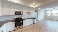 Located at 5377 Quail Run Rd in Riverside, California, this well-appointed single-floor residence offers a thoughtfully designed layout with modern finishes throughout. The kitchen is a standout feature, showcasing crisp white shaker cabinetry, a classic subway tile backsplash, dark countertops, and a full suite of stainless steel appliances including a gas range, microwave, dishwasher, and refrigerator — all set atop warm wood-look luxury vinyl plank flooring. The open living area is bright and spacious, equipped with a ceiling fan and direct access to an outdoor balcony, while a stacked washer and dryer unit is conveniently tucked into a dedicated closet nearby. The bedrooms are carpeted for comfort, with neutral tones and window blinds that allow for natural light. The primary bedroom benefits from a generous walk-in closet featuring built-in shelving and multi-rod hanging storage. The primary bathroom is well-equipped with a dual-sink vanity, dark countertops, white cabinetry, and wood-look flooring. A secondary full bathroom offers a tub-shower combination, wood-look flooring, and a clean, minimalist design. Recessed lighting and a consistent neutral color palette tie the entire space together with a fresh, modern aesthetic.
