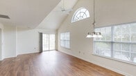 Located at 6690 Hauser Rd in Macungie, PA, this 2-bedroom, 3-bathroom single-floor residence offers a well-designed layout with a thoughtful blend of architectural character and functional living spaces. The open living and dining area immediately impresses with dramatic vaulted ceilings that soar overhead, a distinctive arched transom window that floods the space with natural light, and warm hardwood-style flooring throughout. A ceiling fan and elegant pendant chandelier add to the ambiance, while sliding glass doors lead directly to a private balcony overlooking the surrounding community and greenery. The kitchen is equipped with warm oak cabinetry, generous counter space with granite-look laminate surfaces, and a deep stainless steel sink. The spacious primary bedroom features its own vaulted ceiling, a ceiling fan, and a large window framing outdoor views. The second bedroom offers hardwood-style flooring and ample natural light. Three bathrooms serve the home, including one with a full tub-shower combination and tile flooring with a clean, classic pedestal sink setup. Additional highlights include four closets for abundant storage, a dedicated laundry area, and a connected hallway tying the layout together efficiently. The balcony provides a pleasant outdoor retreat with open views of the landscaped surroundings.