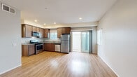 Located at 112 East 31st Street in National City, CA, this single-floor, 3-bedroom, 2-bathroom home offers a well-organized layout designed for comfortable everyday living. The open-concept kitchen and living area serves as the heart of the home, featuring warm wood cabinetry, granite-style countertops, stainless steel appliances including a refrigerator, gas range, microwave, and dishwasher, and recessed lighting throughout. Light wood-tone flooring runs seamlessly across the space, enhancing the bright and clean aesthetic. A sliding glass door in the living area allows natural light to pour in and provides direct access to the outdoors. The three bedrooms are finished with the same light wood flooring and neutral wall tones, creating a calm and versatile environment. The primary bedroom offers a generous footprint with direct access to a closet. Both bathrooms are appointed with tub-shower combinations, tile surrounds, wood-toned vanities, and clean white finishes. Additional storage is provided by two closets, including a well-sized walk-in with built-in shelving and hanging rods. A connecting hallway ties the layout together efficiently. The overall design is clean, modern, and move-in ready.