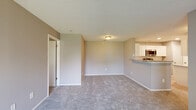 This well-appointed 2-bedroom, 2-bathroom residence at 3543 Idlewood Ter in Indianapolis, Indiana offers a practical and comfortable single-floor layout. The open-concept kitchen and living area forms the heart of the home, where the kitchen stands out with white shaker cabinetry, granite countertops, a subway tile backsplash, stainless steel appliances including a range, microwave, dishwasher, and refrigerator, and light wood-look flooring. A peninsula with a undermount sink provides a natural transition into the carpeted living area, which is bathed in natural light and opens to a private balcony through a sliding glass door. Both bedrooms feature plush carpet, neutral gray walls, and ample natural light from large windows; the primary bedroom includes ceiling fan and access to a dedicated closet. The unit is well-equipped with five closets throughout, offering generous storage. Both bathrooms share a consistent design with granite-topped vanities, white tile tub-shower combinations, and wood-look flooring. A dedicated laundry area adds everyday convenience. Textured ceilings and neutral tones throughout create a clean, move-in-ready atmosphere.
