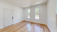 Located at 48 High St in Bristol, Connecticut, this efficiently designed single-floor unit offers a well-appointed layout comprising a kitchen, living room, and bathroom. Light natural hardwood flooring runs continuously throughout the space, lending warmth and visual cohesion to every room.

The kitchen is a standout feature, showcasing crisp white shaker cabinetry, white quartz countertops, and a classic subway tile backsplash. Stainless steel appliances — including a range, over-the-range microwave, and dishwasher — are complemented by an in-unit washer. A matte black pendant light and matching sink fixtures add a modern, contrasting accent, while multiple windows fill the space with natural light.

The living area is bright and open, with recessed lighting, clean white walls, and large windows that invite outdoor views. A striking exposed brick column and a sleek barn door provide architectural character, bridging the living space and kitchen with a touch of industrial charm.

The bathroom continues the cohesive design language with white subway tile lining a walk-in shower, matte black fixtures, and hardwood-style flooring. Recessed lighting keeps the space feeling clean and functional.

Overall, this unit delivers a fresh, modern aesthetic with thoughtful details and a bright, welcoming ambiance throughout.