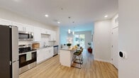 Located at 6 Powder Mill Rd in Maynard, MA, this well-appointed 2-bedroom, 2-bathroom residence offers a thoughtfully designed single-floor layout with a clean, contemporary aesthetic throughout. The open-concept kitchen and living area serves as the heart of the home, where the kitchen impresses with crisp white shaker cabinetry, light quartz countertops, stainless steel appliances including a full-size refrigerator, electric range, and microwave, all complemented by light hardwood-style flooring. The adjoining living room is bright and inviting, featuring a sliding glass door that opens to a private balcony, filling the space with natural light and outdoor views. Both bedrooms are generously proportioned, carpeted for comfort, and feature large windows that bring in additional natural light. The spacious primary bedroom offers a comfortable retreat with its own dedicated bathroom. Two closets provide practical storage throughout the unit. The two bathrooms are finished in a consistent modern style — one features a tiled shower-tub combination with a white vanity and grey countertop, while the primary en-suite bathroom offers a sleek glass-door walk-in shower. Light hardwood-style flooring in the common areas ties the residence together with a warm, cohesive feel.