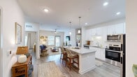 Located at 125 New Hanover St in Beaufort, SC, this single-story residence offers 2 bedrooms and 2 bathrooms within a thoughtfully designed open-concept floor plan. Light-toned luxury vinyl plank flooring flows throughout, complementing the bright, neutral palette that defines the home's coastal aesthetic.

The kitchen serves as a central hub, showcasing white shaker cabinetry, stainless steel appliances, a subway tile backsplash, and a generous granite-topped island with pendant lighting and seating — seamlessly connected to the living area. The living room features vaulted ceilings, a ceiling fan, and a glass door that invites natural light and outdoor access.

The primary bedroom is a well-sized retreat with dual windows, a ceiling fan, and direct access to a private en-suite bathroom. The bathroom is finished with granite countertops, a glass-enclosed walk-in shower, and leads directly into a dedicated walk-in closet with wire shelving. A second bedroom and additional full bathroom provide comfortable accommodations for guests.

Completing the home is a dedicated laundry room with a full-size washer and dryer and overhead wire shelving for extra storage. Two closets throughout further enhance the home's practical storage capacity.