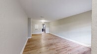 Located at 2055 Dowlen Road in Beaumont, Texas, this single-story 2-bedroom, 2-bathroom unit offers a clean, modern aesthetic throughout. Light wood-look flooring flows seamlessly across every room, complementing the neutral gray-toned walls and crisp white trim. The open-concept living and dining area provides a generous, airy feel, with natural light filtering in and a clear sightline to the kitchen. The kitchen is well-appointed with gray shaker-style cabinetry, white quartz countertops, black hardware, an electric range, and in-unit washer and dryer — all finished with a bright window for added natural light. Both bedrooms are comfortably sized, each featuring ceiling fans, windows with blinds, and dedicated closets. The spacious primary bedroom includes direct access to an ensuite bathroom. Both bathrooms are styled with gray vanity cabinetry, white quartz countertops, black hardware, and light wood-look flooring, with one bathroom offering a tub-shower combination. A hallway connects the private areas of the unit. Additional highlights include a balcony for outdoor access and ample closet storage throughout. The overall design is cohesive, contemporary, and move-in ready.
