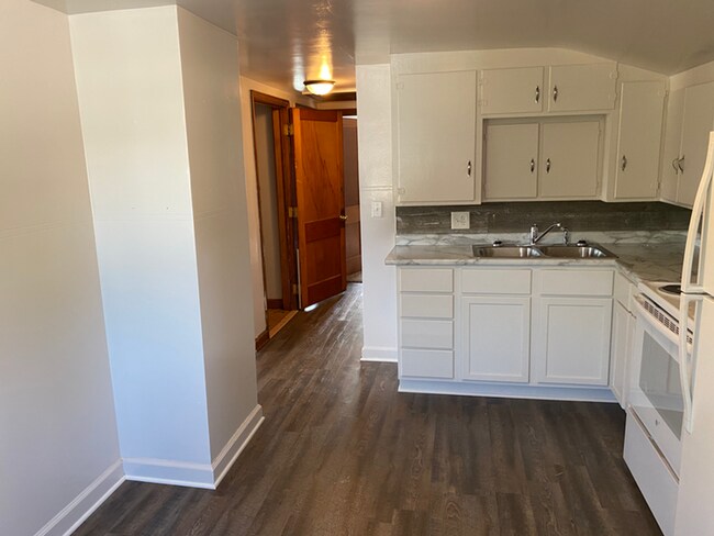 Dormitorio principal espacioso con grandes ventanales y espacio suficiente para un juego completo de muebles de dormitorio. - 1202 S 11th Ave